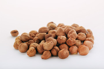 A pile of hazelnuts at white background