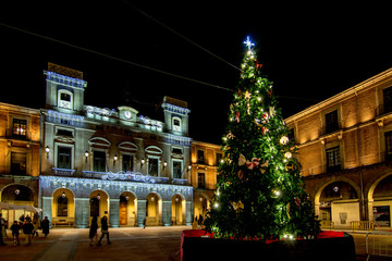 Christmas Tree with lights glowing on a town square in Avila , Spain