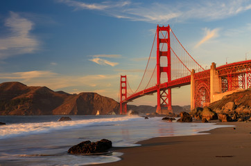 Golden Gate Bridge view from the hidden and secluded rocky Marshall's Beach at sunset in San Francisco, California