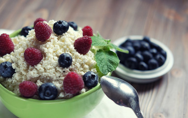 Cottage cheese in green bowl with raspberries and blueberries