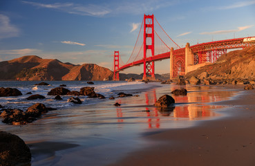 Golden Gate Bridge vue depuis la plage rocheuse cachée et isolée de Marshall au coucher du soleil à San Francisco, Californie