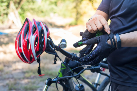 Man with helmet glove for safety riding a bicycle at countryside road along a forest,Cross country riding,cycling activity and sports.