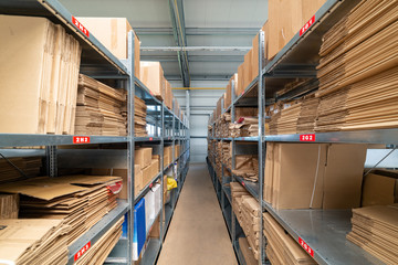 Obraz premium Warehouse shelves with cardboard boxes and packs in paper packaging