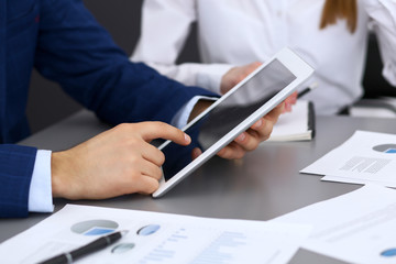Businessman using touchpad at meeting, closeup of hands
