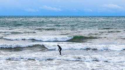 Surfer is trying to ride on the intense waves.