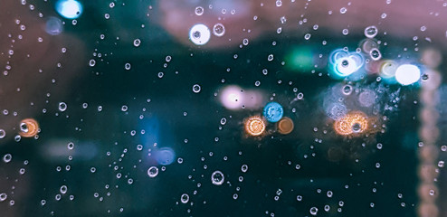 Drop  of water rain on window glasses surface with City light blur background.