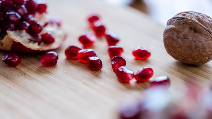 The pomegranate and with fruits on the wooden plate