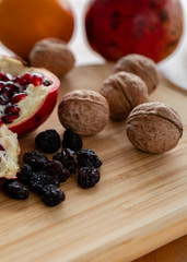 The pomegranates and fruits and nuts on the wooden plate