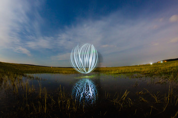 Futuristic glowing sphere reflected on the river surface