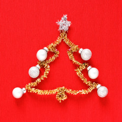 Gold christmas tree with colored balls on red background