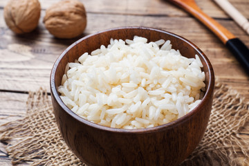White boiled rice in a wooden bowl. Rustic style.
