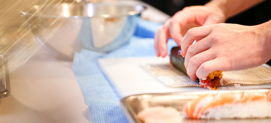 Obraz na płótnie Canvas chef hands preparing japanese food, chef making sushi, Preparing Sushi roll