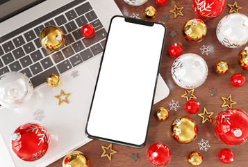 Mobile phone laying on laptop with christmas baubles mockup 3d rendering