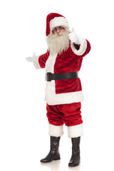 happy santa claus points finger and makes inviting gesture