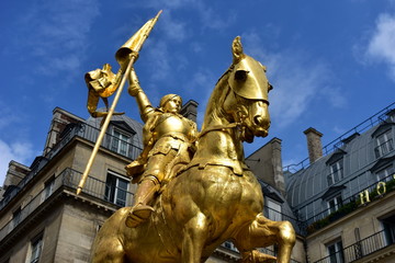 Paris, France. Jeanne d’Arc golden statue. Blue sky with white clouds.