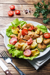 Stewed pieces of chicken with vegetables on a plate.
