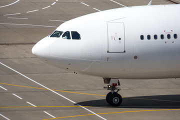White modern passenger civil airplane taxiing at international airport
