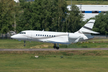 White modern private jet landing at airport