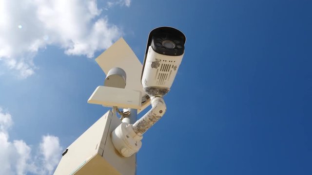 Outdoor security camera on blue sky background