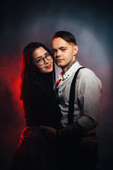 Couple in fashionable clothes on a dark smoky background