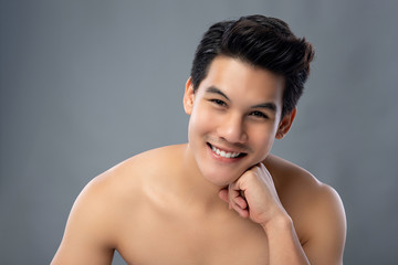 Obraz premium Portrait of handsome Asian man looking at camera with hand on chin