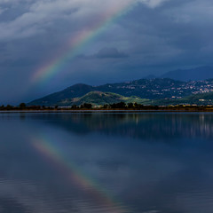 Naklejka na ściany i meble The rainbow is reflected in the waters of Lake Massaciuccoli, Lucca, Tuscany, Italy
