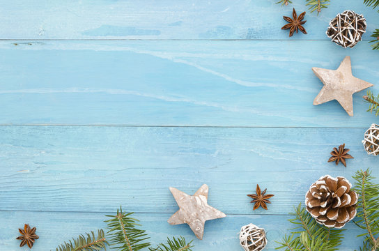 Christmas coner frame. Rustic blue wooden panks with christmas tree,anice star, pine cones and fir tree. Winter holiday seasonal greetings card. Xmas background. Top view trendy flat lay design