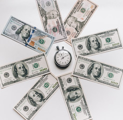 Banknotes lie in the shape of a circle around the clock. Stopwatch and dollars. Time is money concept.Money loan. Credit debt.