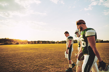 Fototapeta na wymiar Team of American football players walking off a sports field