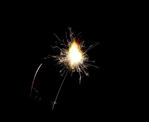 Ignited sparkler isolated on black background with clipping path