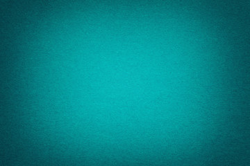 Texture of old dark turquoise paper background, closeup. Structure of dense emerald cardboard.