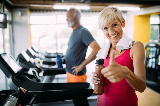 Senior People Running In Machine Treadmill At Fitness Gym Club