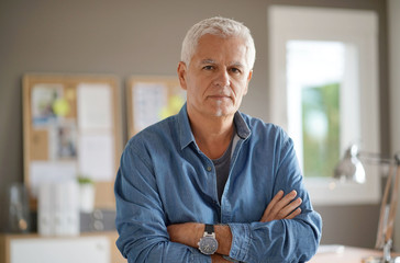 Senior man in office, looking at camera