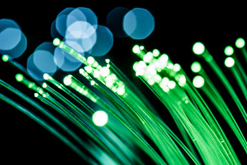 Bundle of optical fibers with green light. Black background.