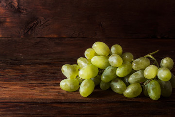 White Grapes on a wooden background with water splashes. Fresh fruit concept, new crop