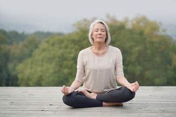   Serene senior woman meditating outdoors