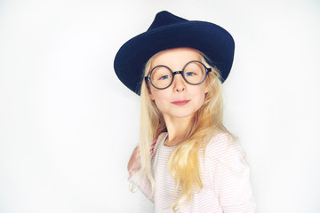Cute little girl wearing a hat and glasses smiling