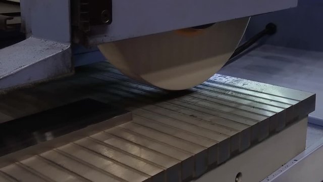 Work of an industrial surface grinding machine. Grinding of a flat metal part.