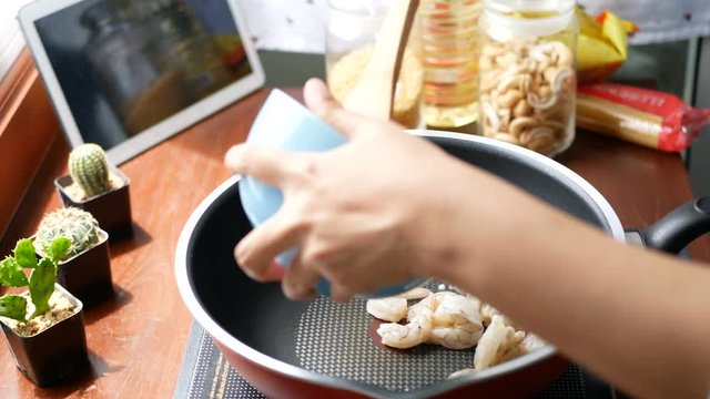 4K. female hand put the shrimp in a pan and stir, prepare ingredients for cooking follow. cooking content lifestyle concept