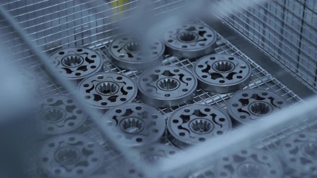 Metal parts manufacturing at factory. Batch of flanges at production conveyor