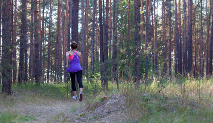 Obraz premium Young female runs in morning forest