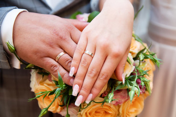 Bride and groom hands with wedding rings