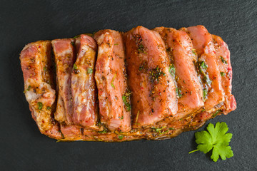 Raw pork fillet marinated with pepper, salt, fresh parsley, honey, paprika, cumin on black stone board, top view - 235639666