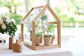 Little flower pot and tree pot in bag with mini wood house for the wedding decoration. - obrazy, fototapety, plakaty