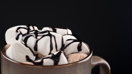 Coffee with marshmallow on a black. Copyspace