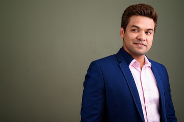 Indian businessman wearing suit against colored background