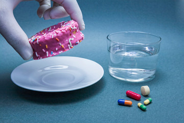 Various medicines to combat diabetes along with a sweet cake and glass water
