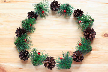 Fototapeta na wymiar Christmas wreath on wooden background. Christmas wreath in minimalist style. Copy space. Top view.