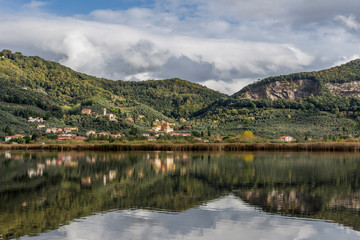 The characteristic village of Massaciuccoli is reflected in the waters of the homonymous lake, Lucca, Tuscany, Italy