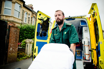 Male paramedic moving the ambulance stretcher